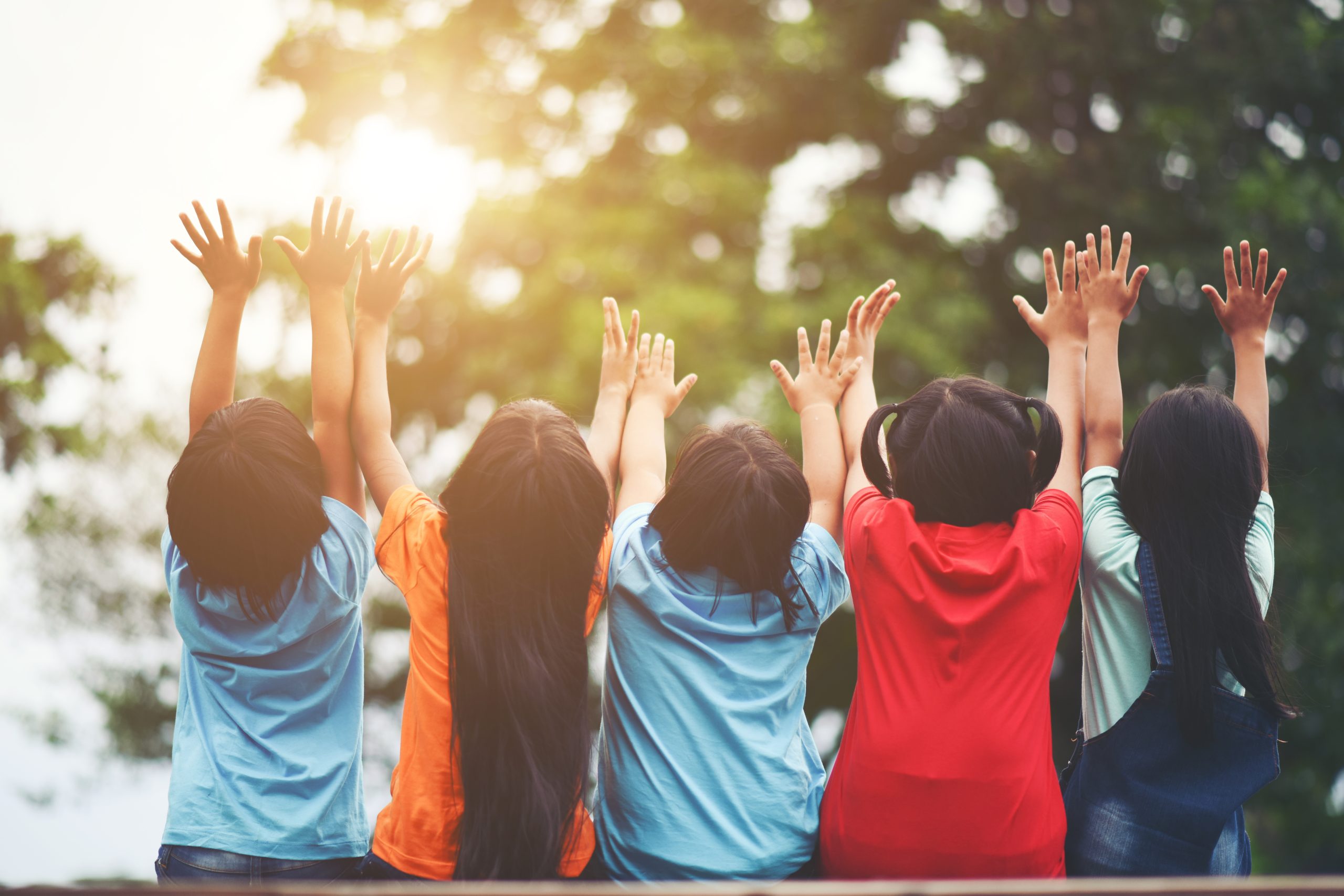 Group kids friends arm around sitting together scaled